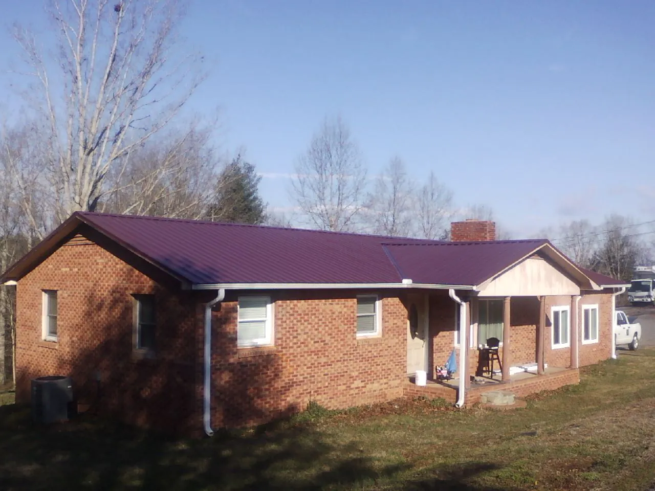 Burgundy metal roof on a brick ranch home with a new addition in Tuscaloosa