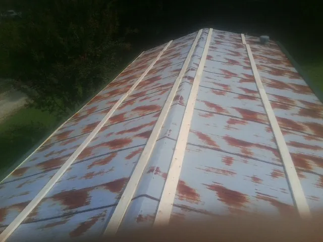 Rusted metal roof panels with new wood purlins before replacement — Storm Damage Roof Repair in Tuscaloosa by Roofing Brothers