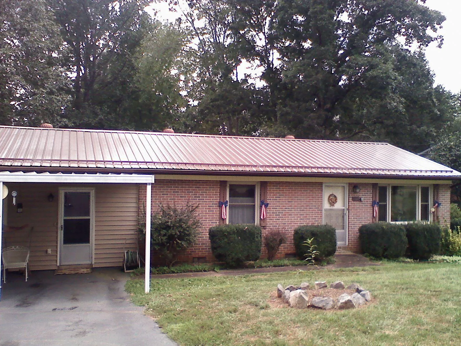 Bronze metal roof and carport on a brick ranch home — Roof Repair work by our crew in Tuscaloosa