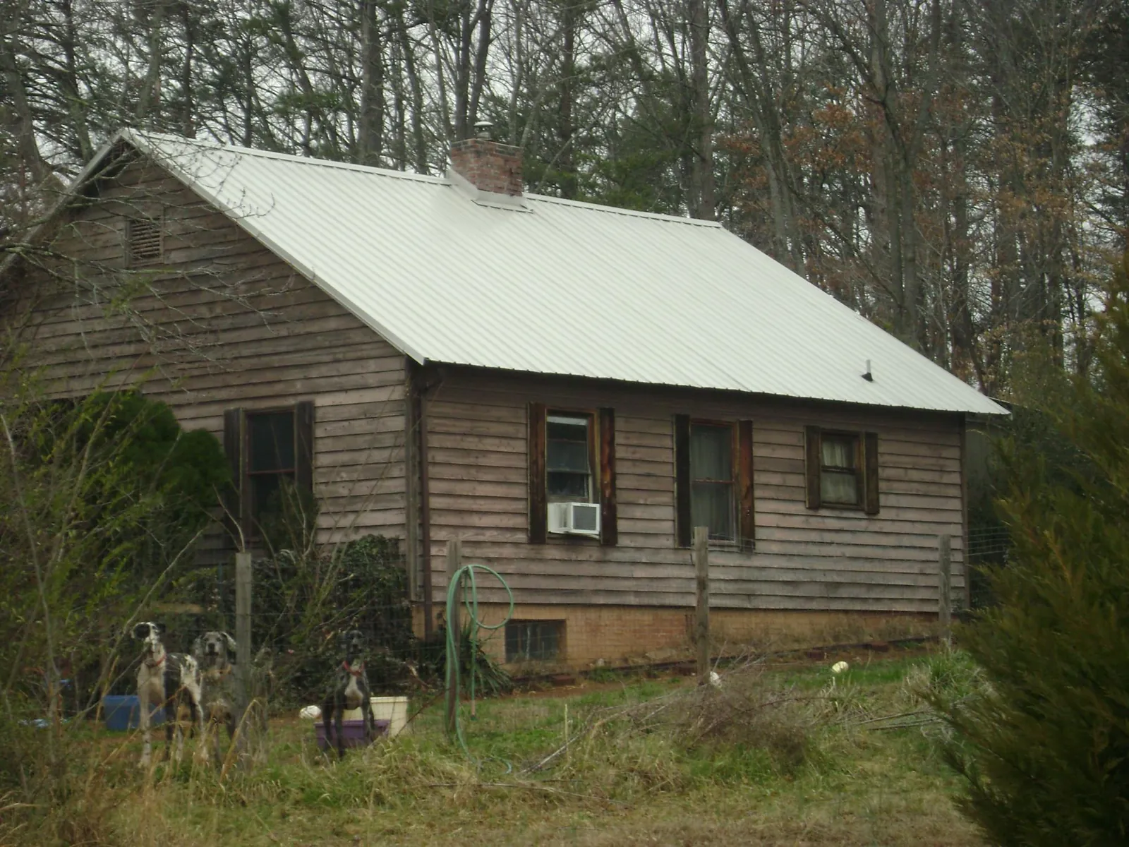 White metal roof on an old wood sided farmhouse, from a Metal Roof Installation job in Tuscaloosa